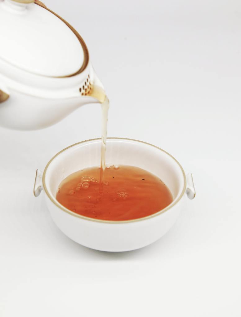 tea pours into white teacup photo