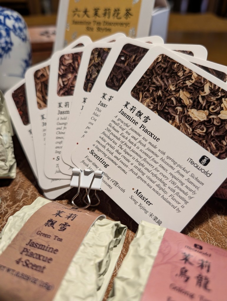 Display of the Jasmine Tea Discovery box featuring various tea varieties and educational cards on a decorative background.